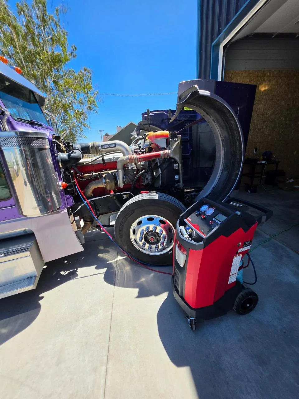 Purple semi truck connected to air-conditioning service equipment